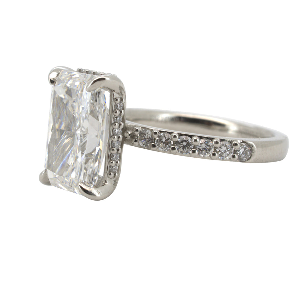 Diamond ring with a large rectangular diamond and smaller diamonds on the band against a white background
