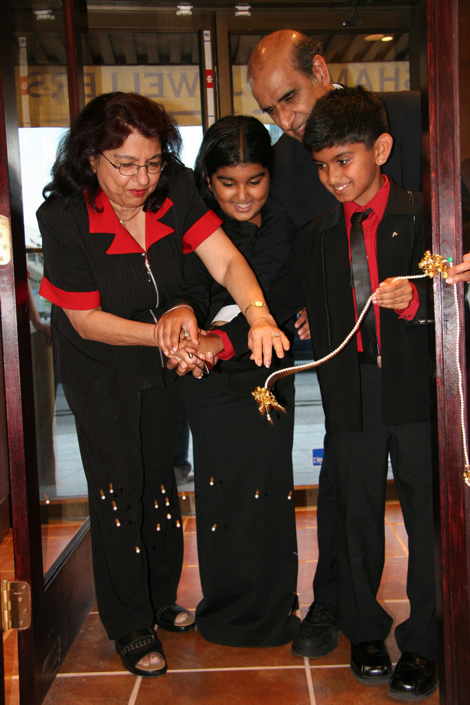 Freeda and Family cutting a Strand of genuine pearls to bless the new store with abundance during the grand opening in 2005